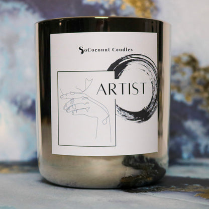 Image: "Artist" candle, 12 oz. glass container with coconut wax and wooden wick. A symphony of 11 essential oils for an inclusive and harmonious fragrance experience. 