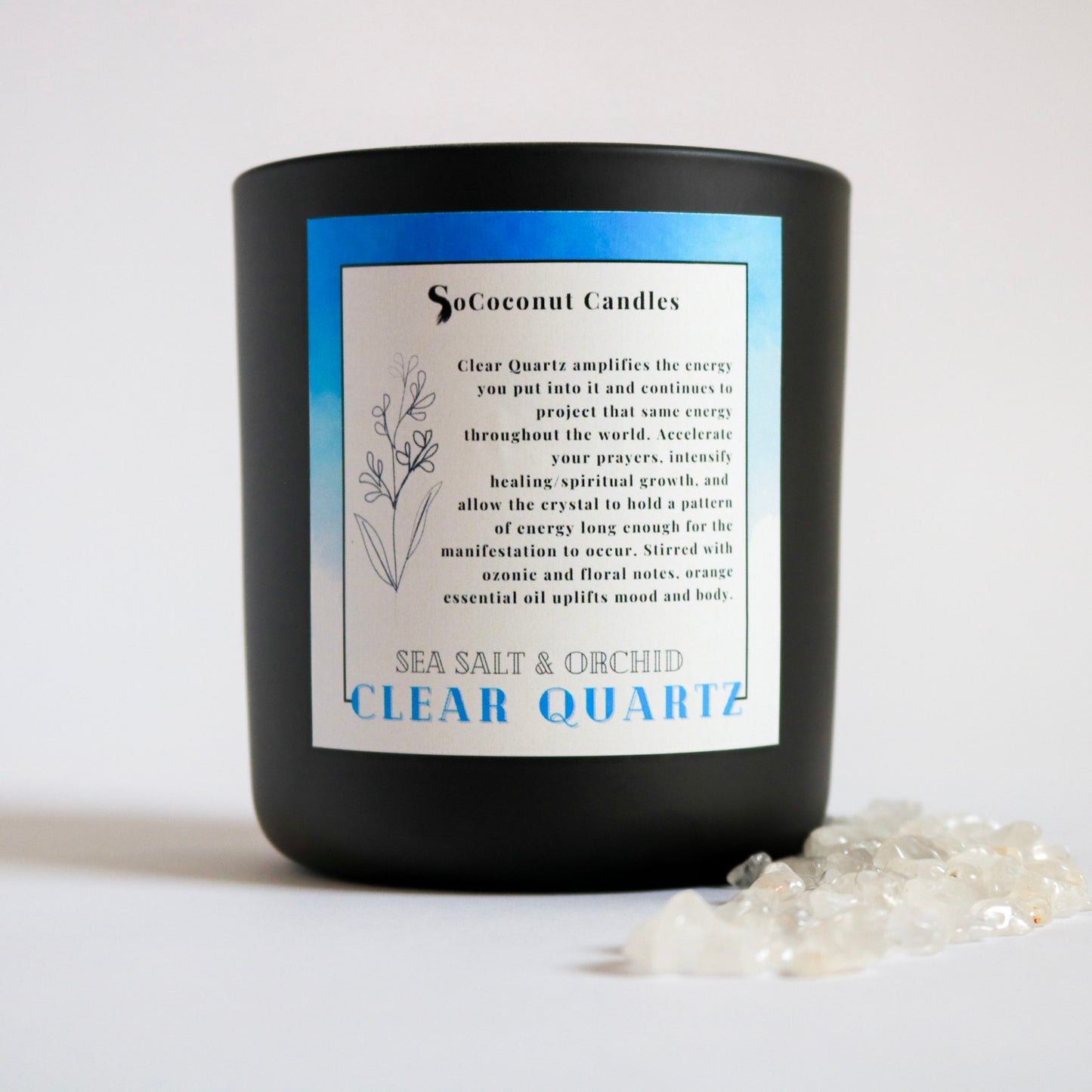 Alt: Sea Salt & Orchid candle with ozonic freshness, delicate freesia, warm amber, and sweet orange peel notes. Adorned with clear quartz for amplified energy and manifestation. Serene florals to illuminate your space. 🕯️🌊🌸