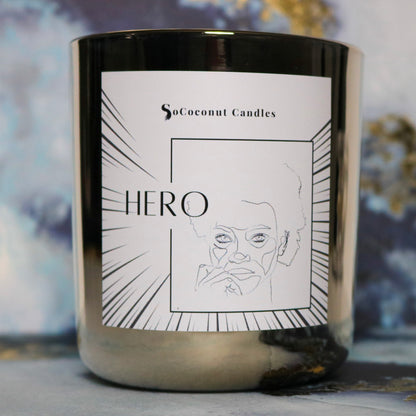 Image: Hero: A 12 oz. candle with saffron, incense, and leather. Essential oils of pine, juniper, and clove bud. Celebrate unity in a design embracing inclusivity. 